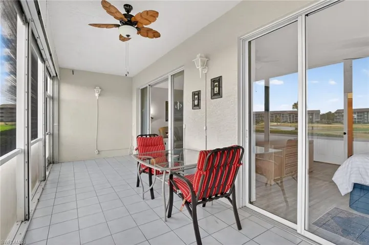 Sunroom / solarium with healthy amount of natural light and a ceiling fan