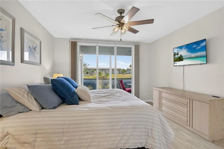 Bedroom featuring access to outside, a ceiling fan, and light wood-style flooring