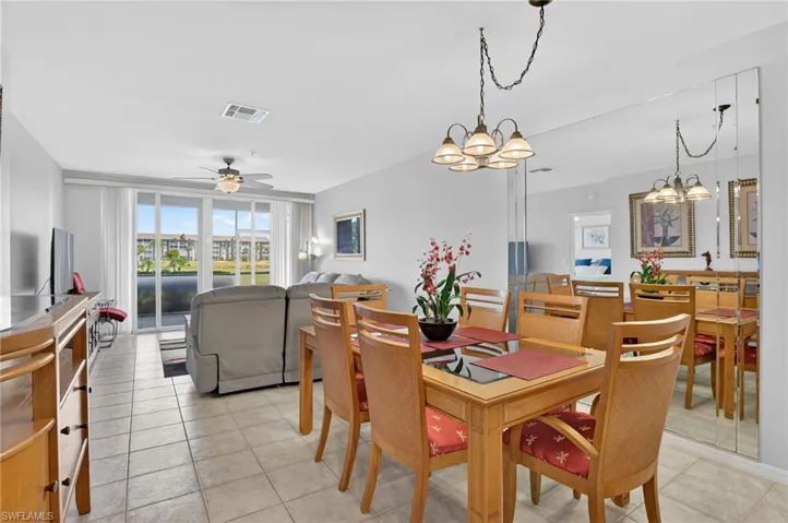 Dining space featuring ceiling fan, hanging lights, and light tile patterned floors