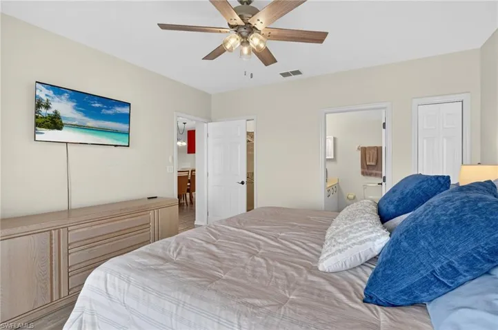 Bedroom featuring ceiling fan, a closet, and ensuite bath