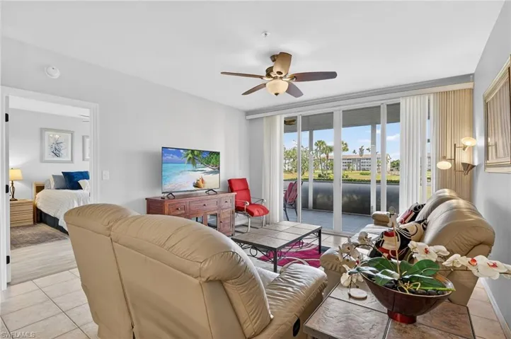 Living area with light tile patterned floors and ceiling fan