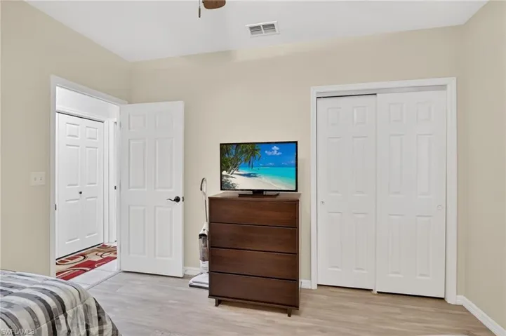Bedroom with light wood-type flooring, a closet, and a ceiling fan