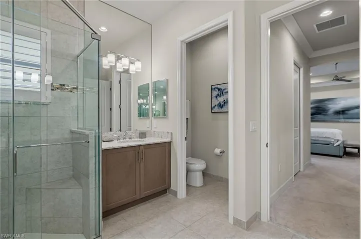 Bathroom with ceiling fan, and full height Mirrors, custom lighting.
