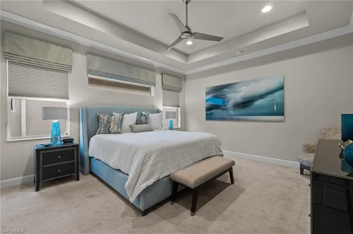 Spacious master bedroom with a Tray ceiling and ceiling fan