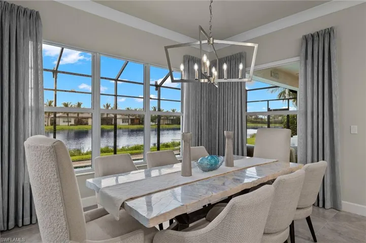 Dining area with plenty of natural light, a water view, and an transitional brushed nickel chandelier
