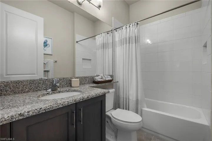 Perfect Full bathroom featuring vanity, toilet, shower / tub combo with curtain, and tile patterned flooring