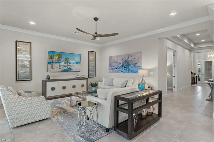 Modern Elegant Living room featuring ceiling fan, light porcelain tile patterned floors, and ornamental crown molding