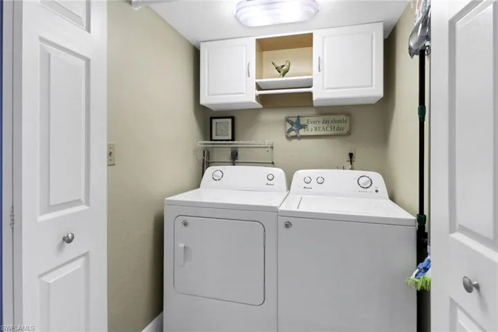 Clothes washing area featuring cabinets and independent washer and dryer