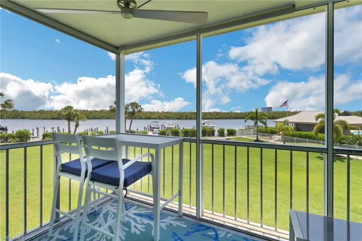 Unfurnished sunroom with a water view and ceiling fan