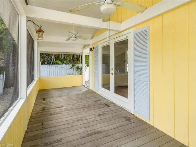 Unfurnished sunroom with beamed ceiling and ceiling fan