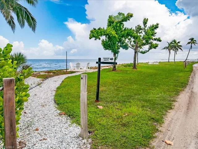 Surrounding community with a water view and a yard