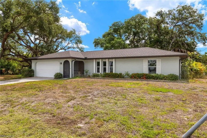 Ranch-style home featuring a front yard and a garage