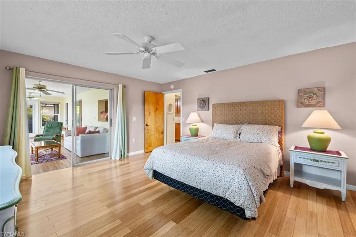 Bedroom featuring a textured ceiling, ceiling fan, and light hardwood / wood-style floors