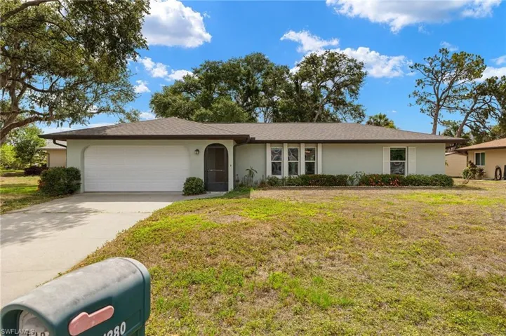 Ranch-style house featuring a garage and a front yard