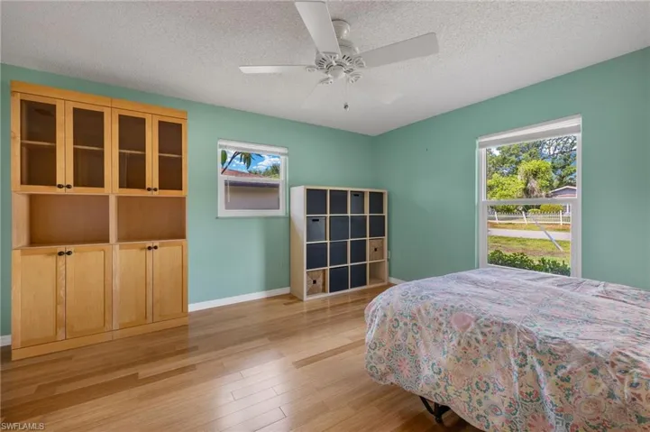 Bedroom featuring ceiling fan, a textured ceiling, and light hardwood / wood-style floors