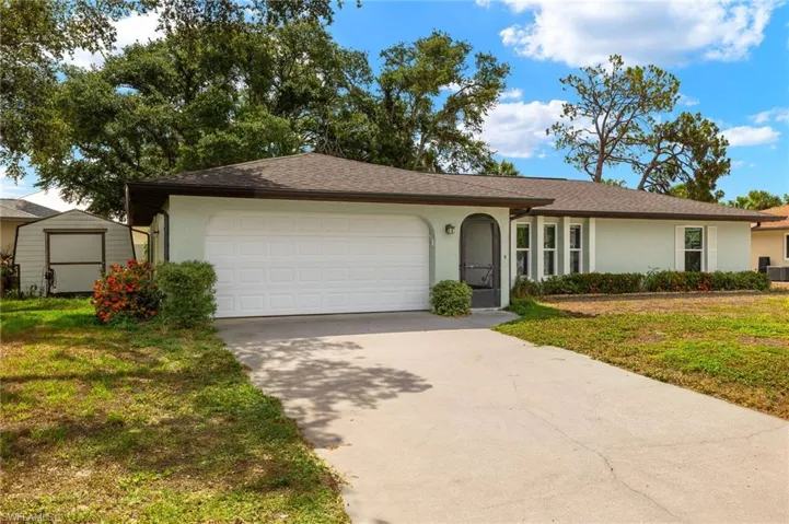 Ranch-style house featuring a front lawn, central AC, and a garage