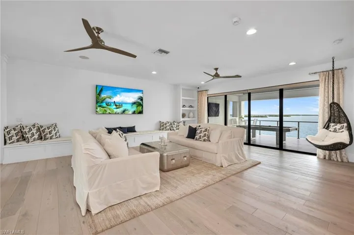 Living room featuring ceiling fan, light hardwood / wood-style flooring, and a water view
