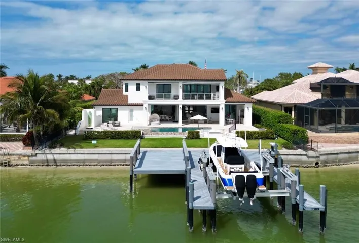 Back of house featuring a water view, a balcony, and a patio area