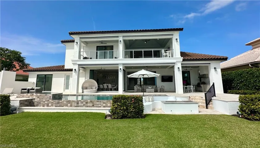 Back of house featuring exterior kitchen, a yard, ceiling fan, a patio area, and a balcony