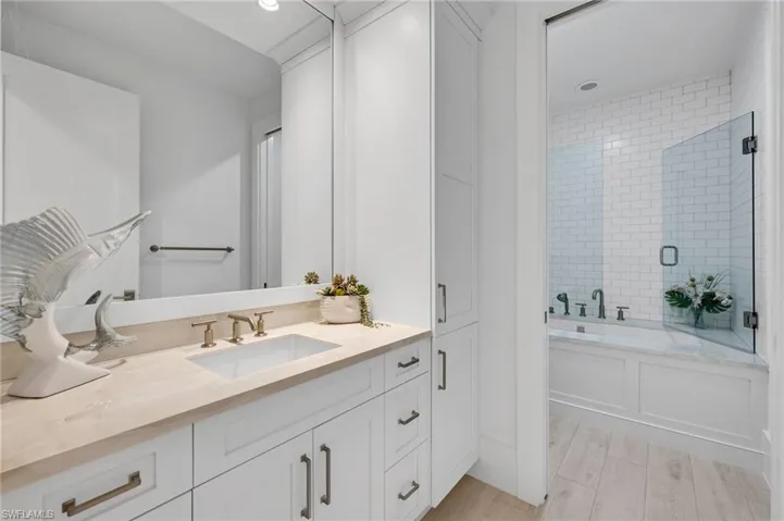 Bathroom featuring separate shower and tub, vanity, and hardwood / wood-style flooring