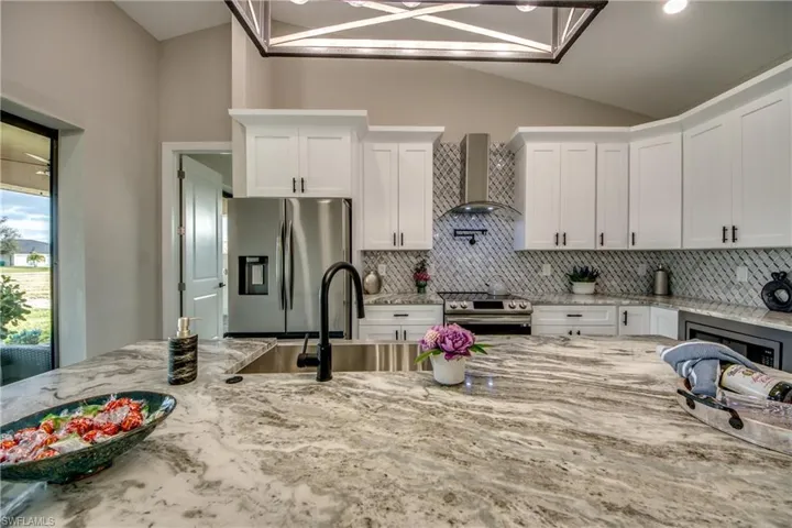 Kitchen boasts Crown Molding, upgraded lighting, Backsplash that goes to top of cabinets, Acrylic Range Hood, and a POT FILLER!!