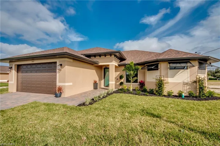 View of front of home with a front yard and a garage