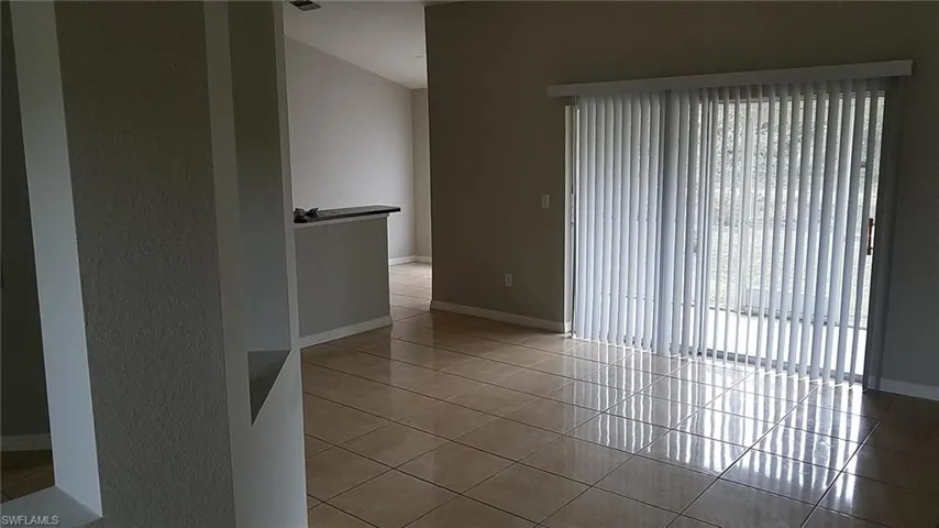 Spare room featuring light tile patterned floors and baseboards