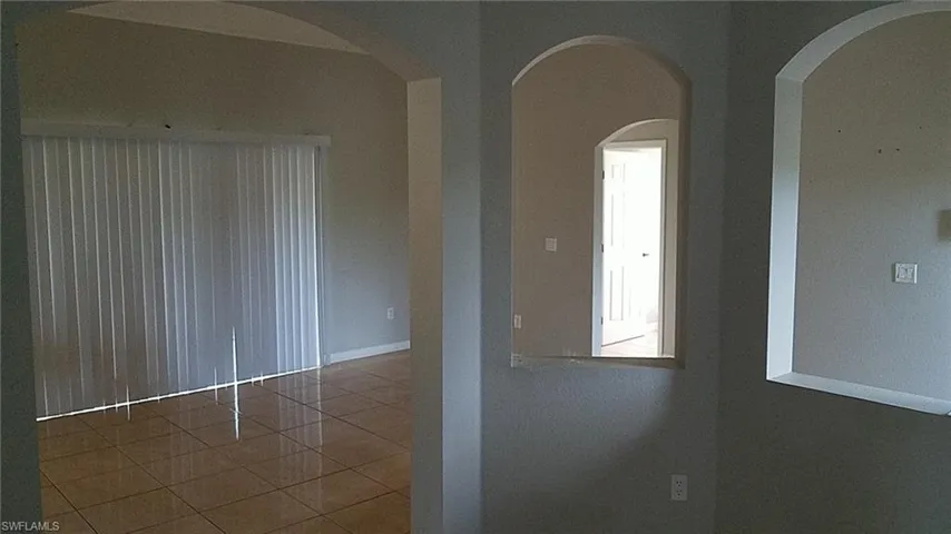 Tiled spare room with arched walkways