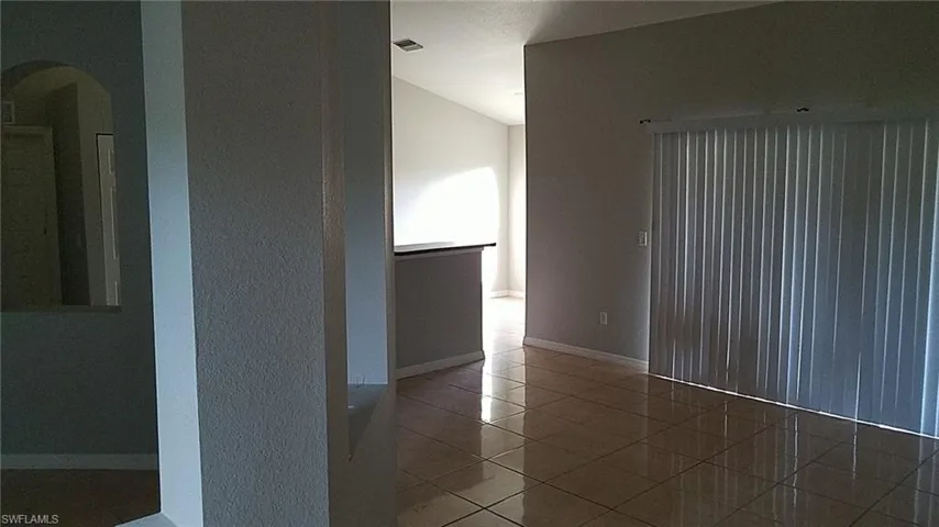 Empty room with light tile patterned floors and baseboards