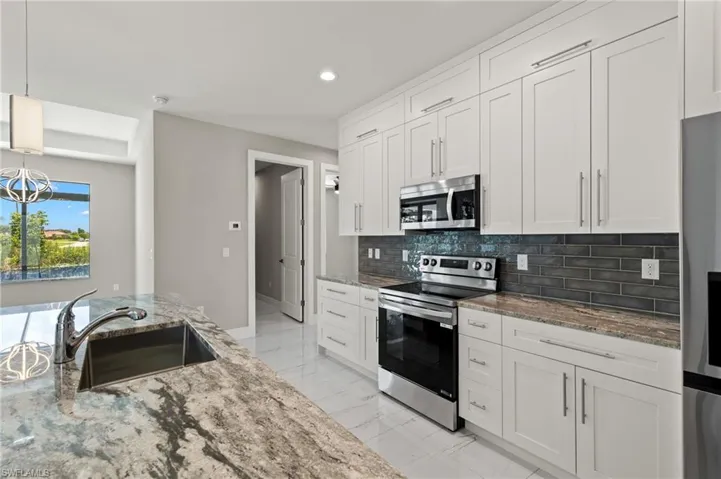 Kitchen featuring white cabinets, sink, and stainless steel appliances
