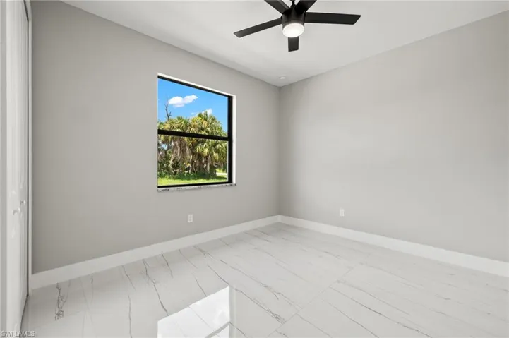 Spare room featuring ceiling fan and light tile patterned floors