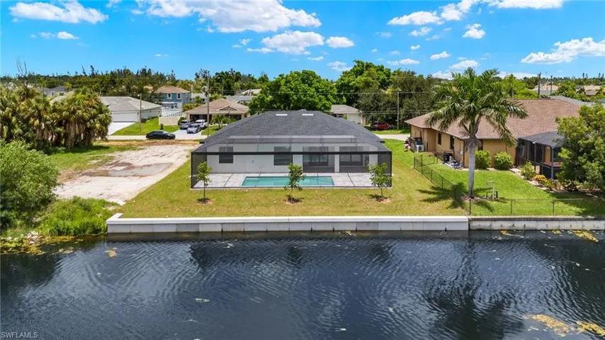 Rear view of property featuring a lawn and a water view