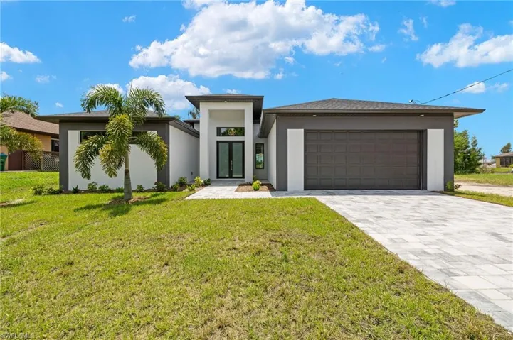 View of front of house with a front lawn and a garage