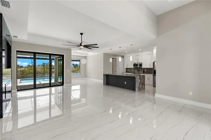 Unfurnished living room featuring ceiling fan and light tile patterned floors