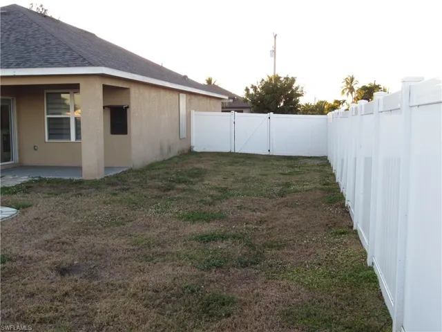 Fenced backyard featuring a gate and a patio
