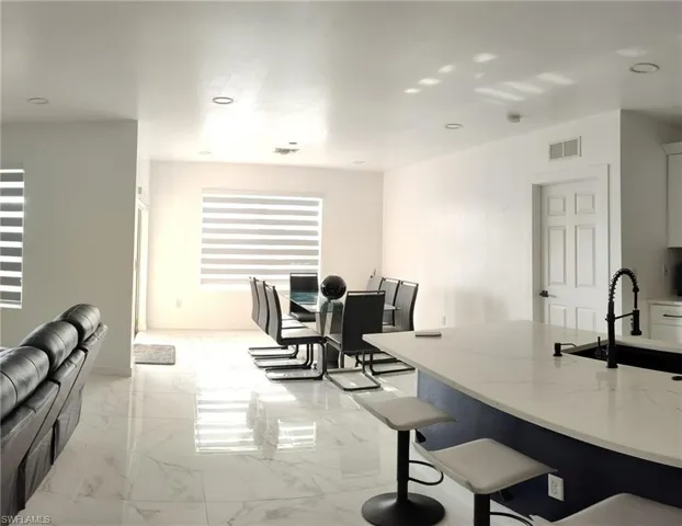 Dining space featuring light marble finish flooring and recessed lighting