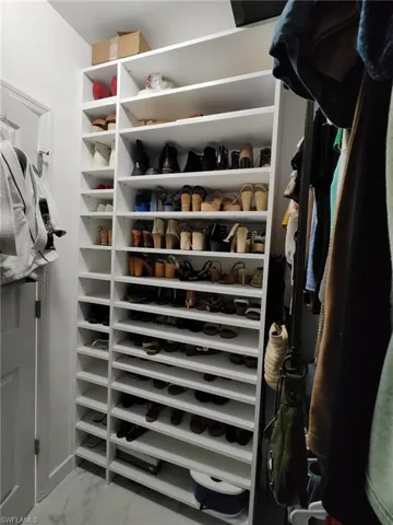 Walk in closet with light marble finish flooring
