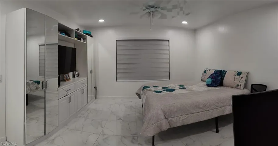 Bedroom featuring ceiling fan, recessed lighting, and light marble finish floors