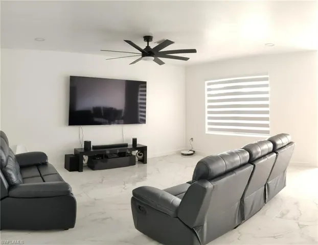 Living room with recessed lighting, light marble finish flooring, and ceiling fan