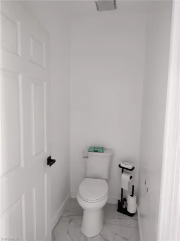 Bathroom with baseboards and light marble finish floors