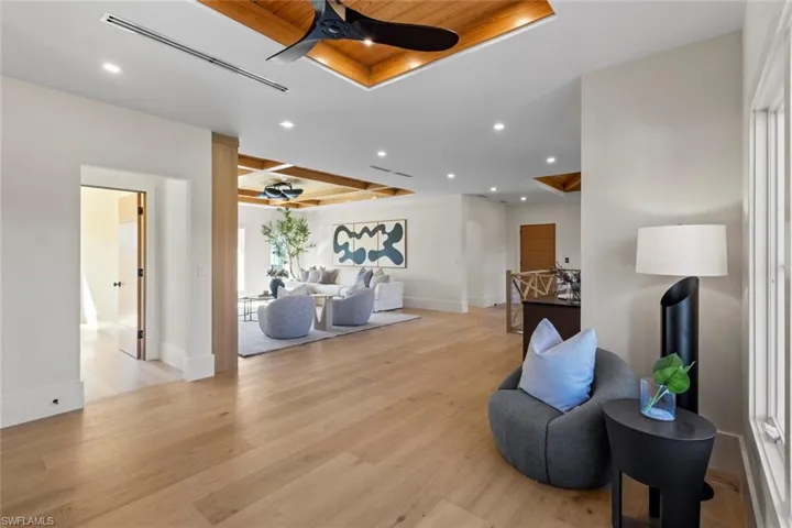 Living area featuring wooden ceiling, ceiling fan, recessed lighting, light wood-type flooring, and a raised ceiling