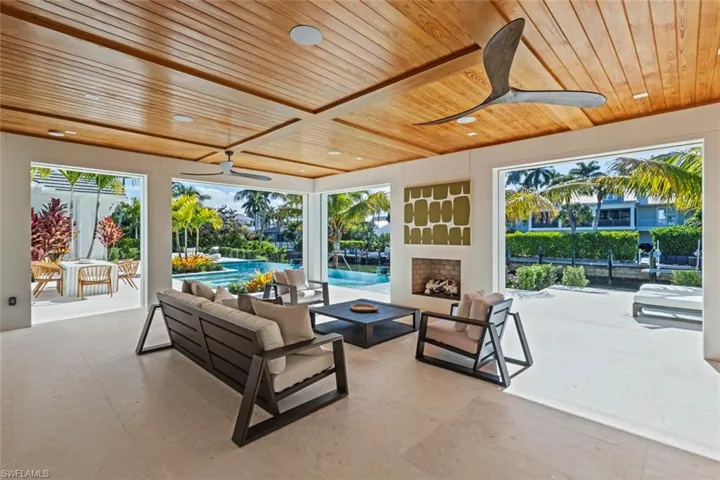 View of patio with a ceiling fan, an outdoor living space with a fireplace, and an outdoor pool