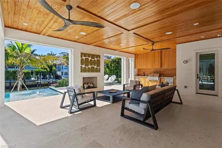 Living room with ceiling fan, wood ceiling, a fireplace, and recessed lighting