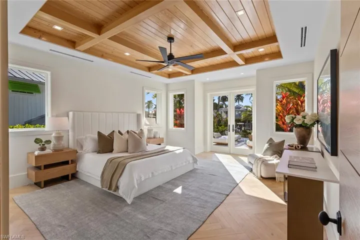 Bedroom with access to outside, a wooden ceiling with exposed beams, ceiling fan, coffered ceiling, and french doors