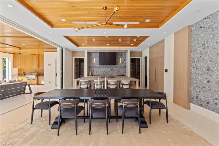 Dining space featuring wood ceiling, a raised ceiling, and an accent wall