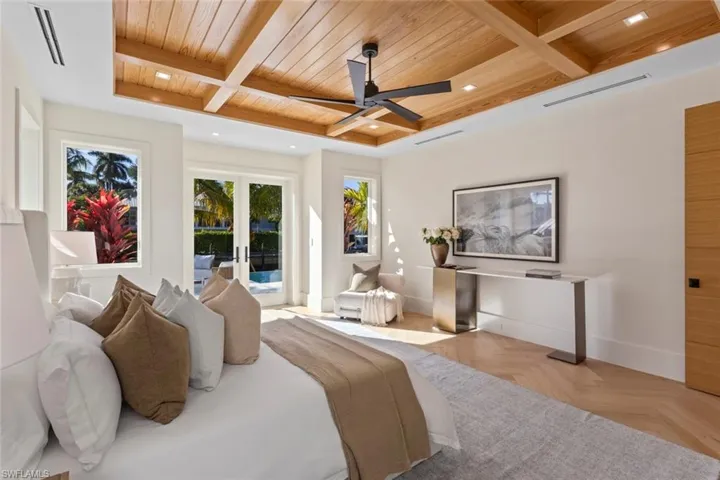 Bedroom with a wooden ceiling with exposed beams, access to outside, coffered ceiling, ceiling fan, and french doors