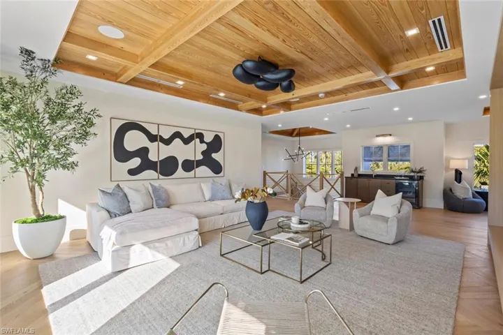 Living area featuring a wood ceiling with exposed beams, parquet floors, and recessed lighting