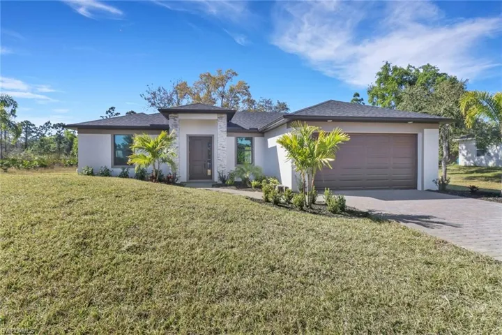 View of front of property featuring a garage and a front yard