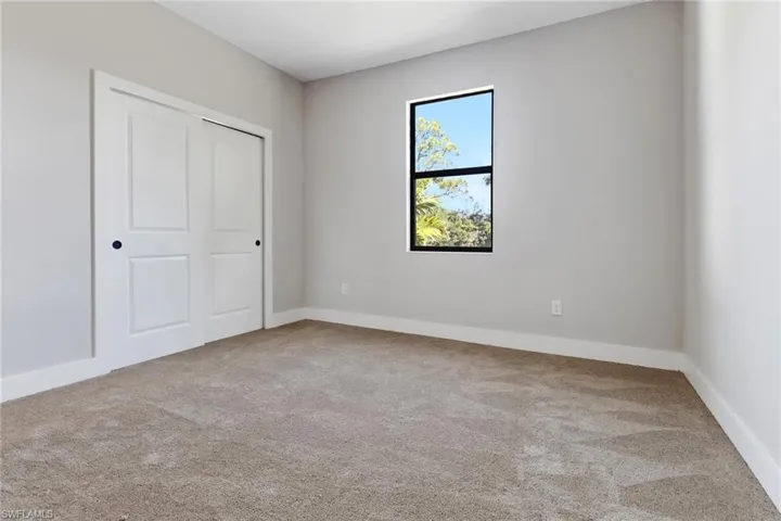 Unfurnished bedroom featuring light carpet and a closet