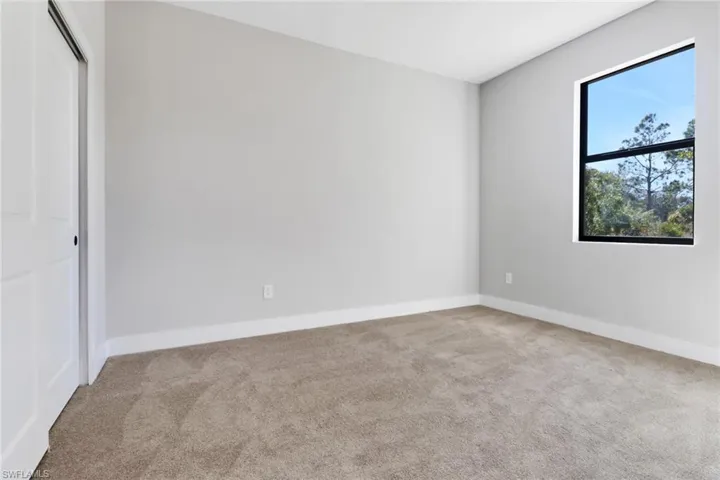 Unfurnished bedroom featuring light carpet and a closet
